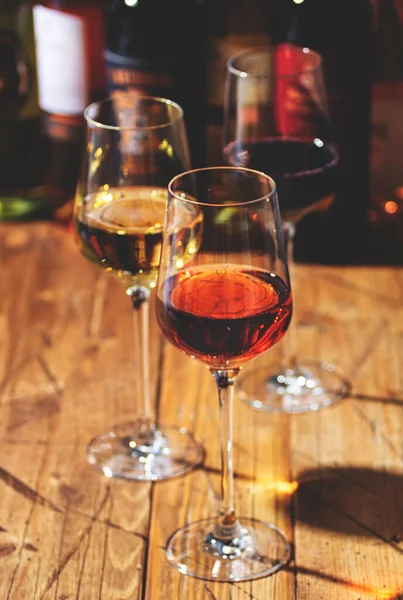 Ahşap zemin üzerinde kırmızı, beyaz ve gül şarabı ve şarap şişeleri koleksiyonu, kopyalama alanı