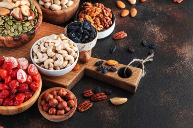 Kavanozda kurutulmuş fındık. Kuru kayısılar, incirler, kuru üzümler, cevizler, bademler ve diğerleri. Sağlıklı besleyici atıştırmalıklar. Kahverengi tablo arkaplanı, kopyala