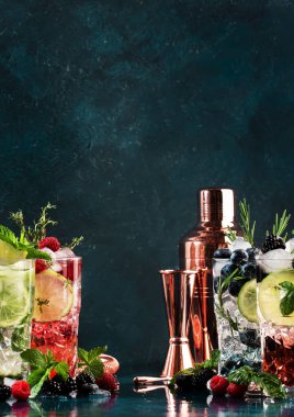Kokteyl ya da kokteyl. Klasik yaz aylarında mavi masa arkasında böğürtlenli, limonlu, otlu ve buzlu viski içilir.