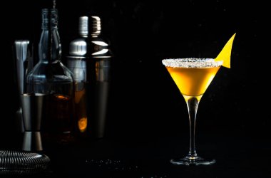 Konyak, likör, limon suyu ve buzlu kokteyl. Siyah arkaplan, çubuk araçları, kopyalama alanı