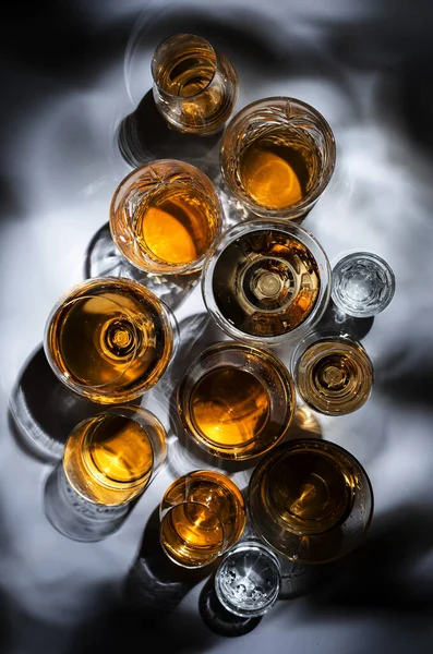 強い飲み物 精神とグラスで蒸留酒 コニャック グラッパ ウォッカ ウイスキーなどの品揃え 強い光と厳しい影を持つ白い背景 — ストック写真