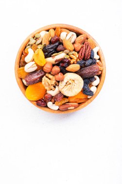 Kavanozda kurutulmuş fındık. Kuru kayısılar, incirler, kuru üzümler, cevizler, bademler ve diğerleri. Sağlıklı besleyici atıştırmalıklar. Beyaz tablo arkaplanı, üst görünüm, kopyalama alanı