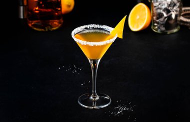 Konyak, likör, limon suyu ve buzlu kokteyl. Siyah arkaplan, çubuk araçları, kopyalama alanı