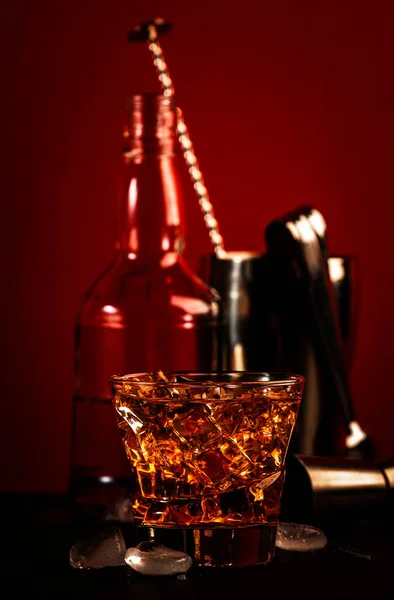スコッチウイスキー アマレットリキュール 氷とゴッドファーザーアルコールカクテル 暗い赤の背景 バーツール コピースペース — ストック写真