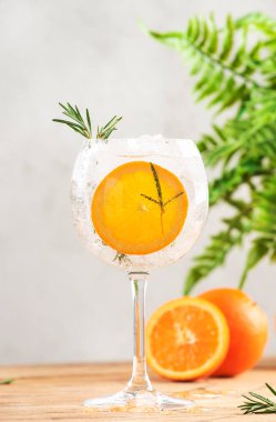 Cin tonik uzun içki, sek cin, acı tonik, portakal, biberiye ve buz, bar aletleri. Kopya alanı olan tahta masa arkaplanı