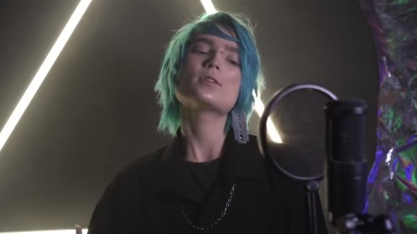 蓝头发的男人或女人在录音室对着话筒唱歌 — 图库视频影像