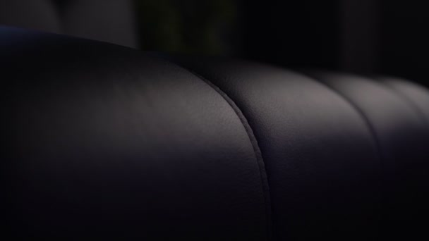 Svart skinnsoffa. Dyra möbler, soffa läder struktur på en mörk bakgrund — Stockvideo