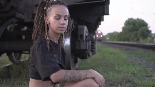 Mladá žena cestovatel na pozadí přijíždějícího vlaku — Stock video