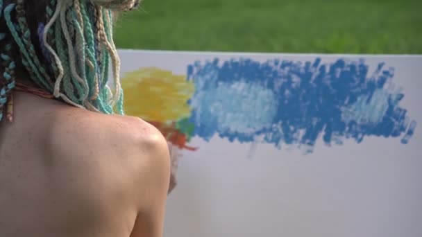 Jeune femme artiste peint un tableau sur toile dans la nature — Video