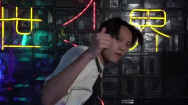 Genç Asyalı adam içeride hip hop dansı yapıyor. Asyalı modern dansçı. Japonca arkaplanda yazılan- karanlıktan aydınlığa izin ver.