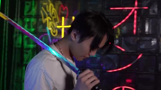 Junger moderner asiatischer Mann mit Katana-Schwert. Die Inschrift auf dem Hintergrund auf Japanisch - Von der Dunkelheit zum Licht — Stockvideo