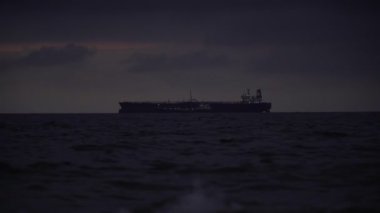 Akşamları denizde kargo gemisi. Denize giden bir kargo gemisi ya da tanker denizde yol alıyor.