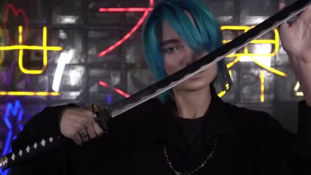 Ein junger Mann mit blauen Haaren hält ein Katana-Schwert in der Hand. Japanisches Anime Cosplay. Inschrift auf japanischem Hintergrund: Weg von der Dunkelheit zum Licht — Stockvideo