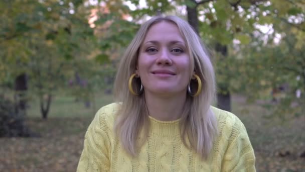 Frau wirft gelbes Herbstlaub in den Park, Zeitlupe. Goldener Herbst, Porträt einer glücklichen Frau — Stockvideo