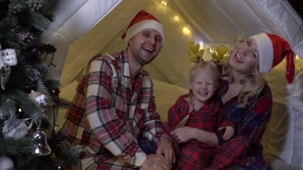 Julen, lycklig familj hemma. Ung familj med barn på nyårsafton — Stockvideo