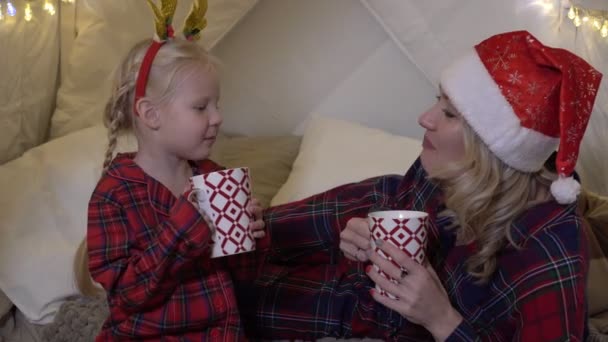 Julstämning, lycklig familj som dricker varm choklad. Mamma med barn i julinredning — Stockvideo