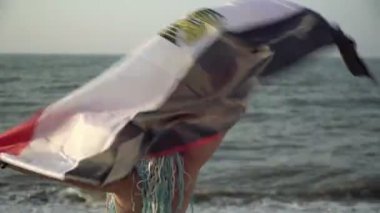 Mısır 'da plaj tatili kavramı. Deniz kenarında Mısır bayrağı taşıyan güzel, mutlu bir kadın.