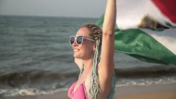 海のビーチでメキシコの旗を持つ美しいセクシーな女性。メキシコのビーチバケーションのコンセプト — ストック動画