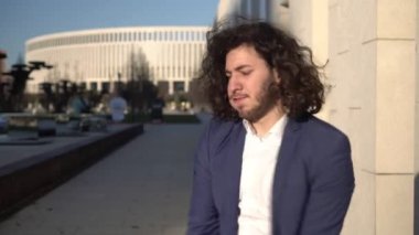 Genç mutlu iş adamı dışarıda dans ediyor. Başarılı bir adamın portresi. İş adamı sokaklarda sevinir ve dans eder.