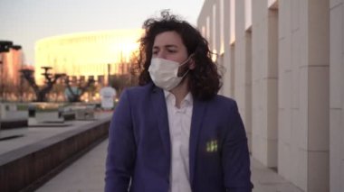 Mutlu adam tıbbi maskesini çıkarıyor. İş adamı, koruyucu maskeyi koronavirüsten çıkarır. Koronavirüsün sonu, salgından sonraki yaşam.