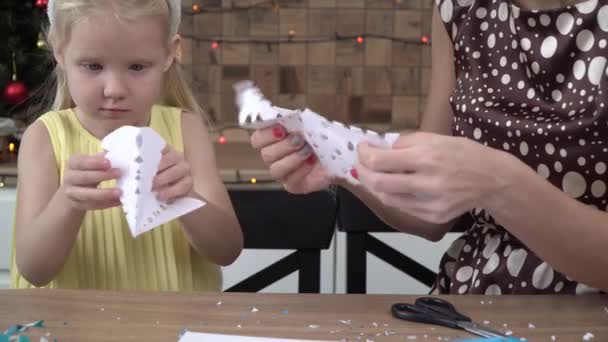 La familia feliz corta los copos de nieve del papel para Navidad. Preparación para el Año Nuevo, manualidades de papel — Vídeo de stock