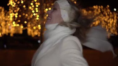 Genç mutlu kadın dışarıda Noel akşamının tadını çıkarıyor. Neşeli kadın Noel 'i sokakta kutluyor.