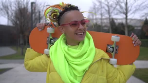 スケートボードと若い幸せな現代の十代の女性。暖かい秋、若いアクティブな都市の女性の肖像画 — ストック動画
