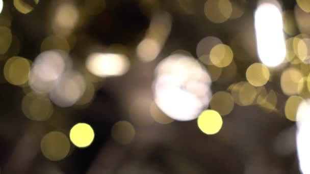 Destaques dourados desfocados e brilho sobre um fundo preto. Iluminação de Natal para fundo desfocado — Vídeo de Stock