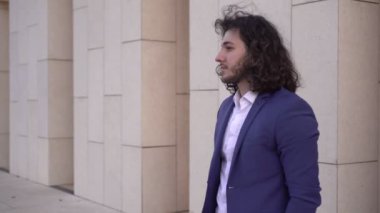 Erkek bir işadamı dışarıda bekliyor ve saatine bakıyor. Çekici bir adam sokakta birini bekliyor.