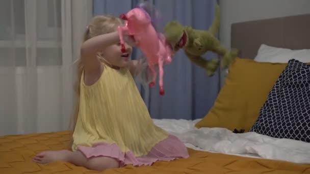 Dziewczynka bawiąca się zabawkami w sypialni. Pięcioletnie dziecko bawi się wieczorem w domu w sypialni. — Wideo stockowe