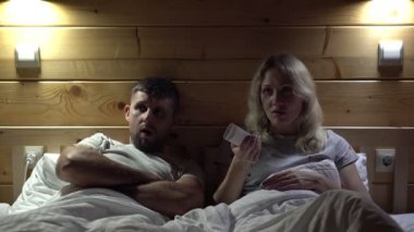 Evli bir çift televizyon izler ve sıkılır. Üzgün insanlar sıkıcı TV izler