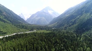 Dağların arkasındaki yeşil vahşi orman. Hava manzarası: Yeşil dağ vadisi ve nehir. Doğanın ve ormanın güzel arka planı