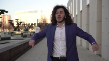 Açık havada dans eden başarılı bir iş adamı. Takım elbiseli neşeli erkek menajer. İş başarısı, zafer veya başarı kavramı