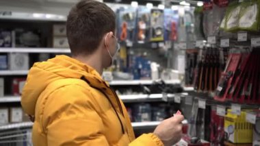 Süpermarkette tıbbi maskeli bir adam bir ürün seçer. Hırdavatçıda koruyucu maske takan biri. Koronovirüs salgını sırasında yaşam tarzı