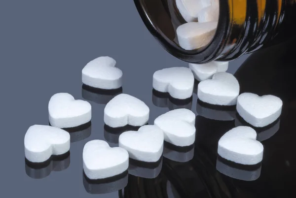 Pills Form White Hearts Spilling Out Glass Vial Dark Mirror — Zdjęcie stockowe