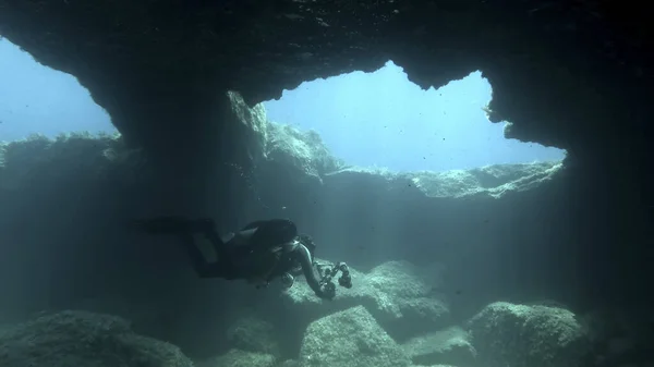 Scuba diver photographer swim in the cave. Cave diving in Mediterranean Sea, Cyprus