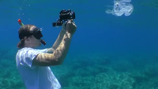 プラスチック汚染:水中のオペレーターは、魚が絡まって死亡するビニール袋を撮影します。. — ストック動画