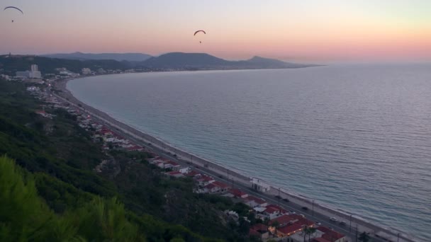 바다 풍경 과 일몰 하늘을 배경으로 패러글라이더를 타고 있는 사람들. — 비디오