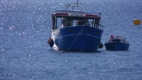 Deniz yüzeyinden yansıyan güneş ışınları demirlemiş iki zevk teknesinin gövdesinde oynar.. — Stok video