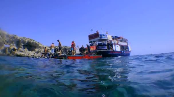 Barco de buceo cerca de la plataforma flotante, la cámara se hunde lentamente en el agua. — Vídeo de stock