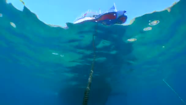 Un recipiente en la superficie del agua, la cámara se mueve a lo largo de la cuerda del ancla. — Vídeo de stock