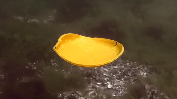 Poluição plástica do oceano: uma placa plástica descartável afunda lentamente no fundo do mar. — Vídeo de Stock