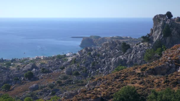 Paesaggio mediterraneo, promontorio roccioso e isola dall'alto della cresta costiera. Rodi, Stegna. — Video Stock