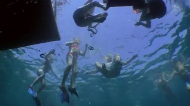 Şnorkelle yüzen: bir grup turist yüzen bir platformun yakınında, alt manzara.