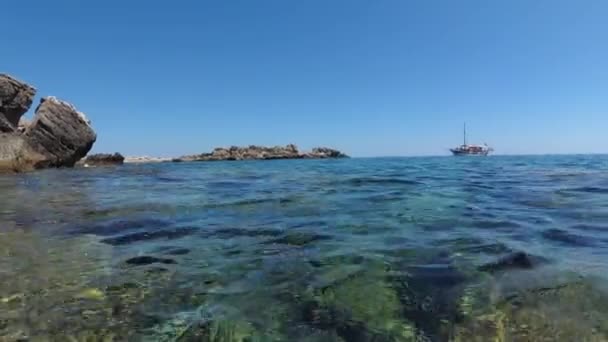 Havslandskap, vintage nöje båt närmar sig en stenig strand, från nivån på havsytan. — Stockvideo