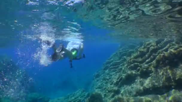 Egy szabadúszó kamerával elúszik egy sziklás part menti sziklán.. — Stock videók