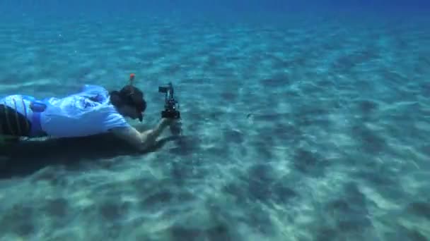一个带着动作相机的自由战士正在沙滩上拍摄鱼 — 图库视频影像