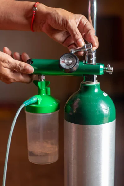 De manos de mujer con tanque de oxigeno medico 'yu kapatın.