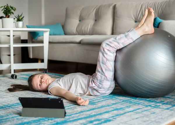 Chica Entrena Línea Una Tableta Para Estirar Con Una Pelota — Foto de Stock