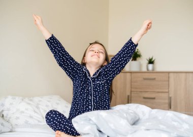 Kız uyanıyor. Kız uyandı ve sabah yatakta gerindi..